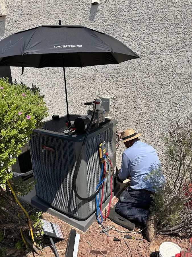HVAC technician performing outdoor AC maintenance in Muskegon Heights